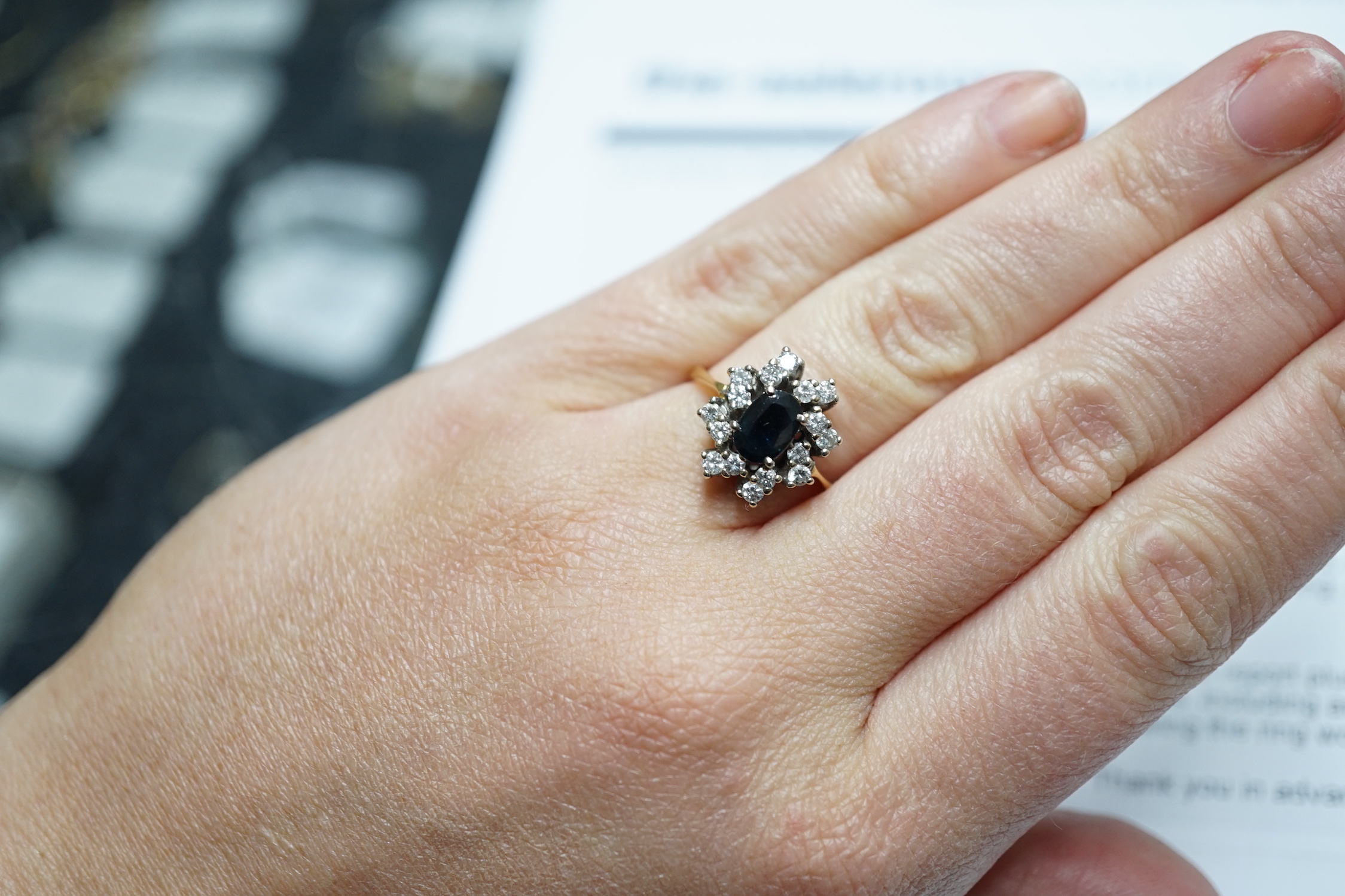 A modern 18ct gold, sapphire and diamond set oval cluster ring, size L, gross weight 4.8 grams.
